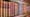 Rangée de livres anciens reliés en cuir dans une bibliothèque, image illustrant la mémoire intellectuelle, la propriété des œuvres et le plagiat assisté par IA.