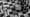 Roi d’échecs blanc renversé sur un échiquier en noir et blanc, parmi des pièces dispersées, illustrant les limites stratégiques de l’intelligence artificielle.